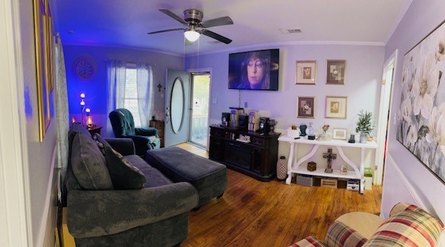 living room featuring ornamental molding, dark wood-type flooring, and ceiling fan