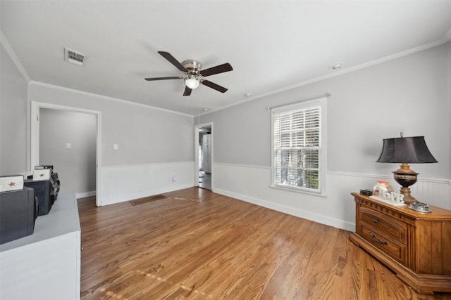 1514 S 13th St, Temple, TX 76504 - unfurnished living room featuring wainscoting, a ceiling fan, wood finished floors, and ornamental molding