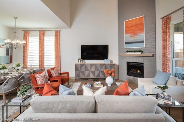 living room with an inviting chandelier, wood-type flooring, and a fireplace