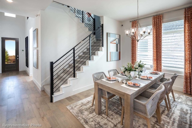 dining area with hardwood / wood-style flooring and an inviting chandelier