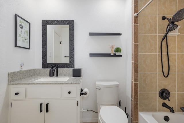 full bathroom featuring vanity, tiled shower / bath, and toilet