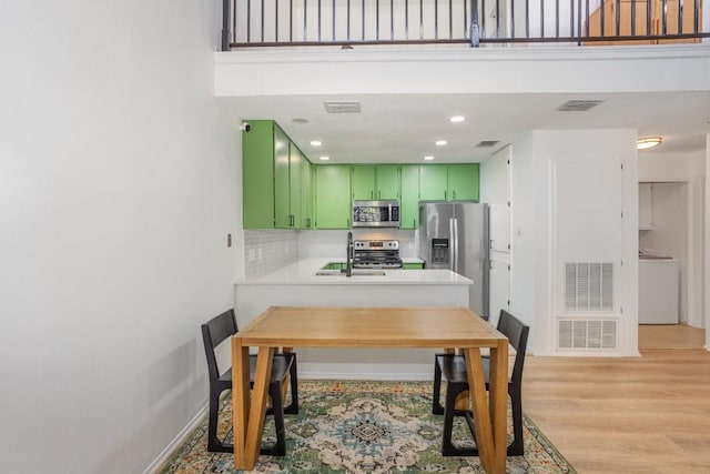 dining space with sink, washer / dryer, and light hardwood / wood-style floors