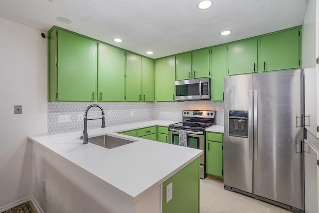 kitchen featuring stainless steel appliances, sink, kitchen peninsula, and green cabinetry