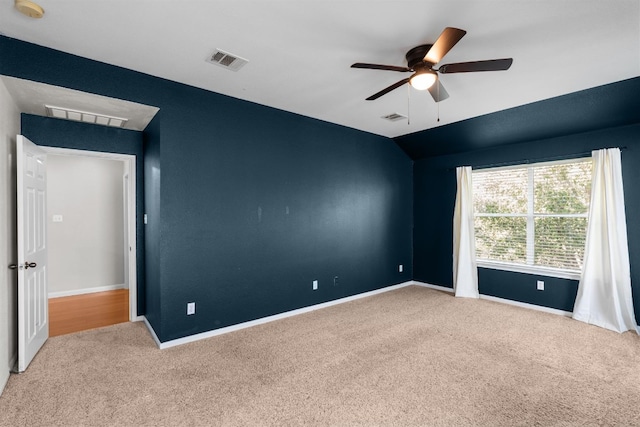 carpeted empty room with ceiling fan and vaulted ceiling