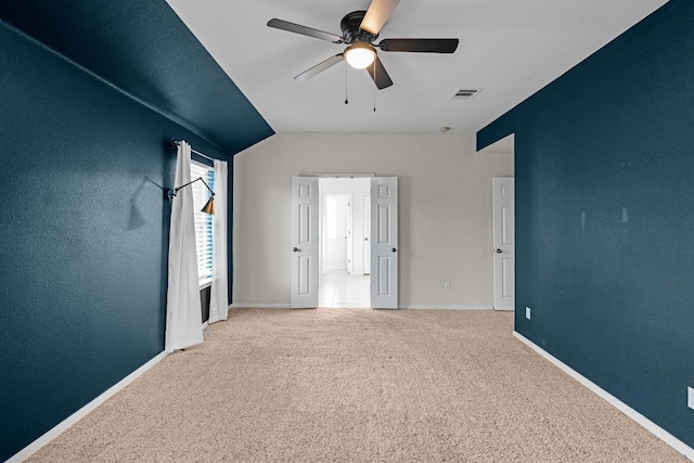 carpeted spare room with lofted ceiling and ceiling fan