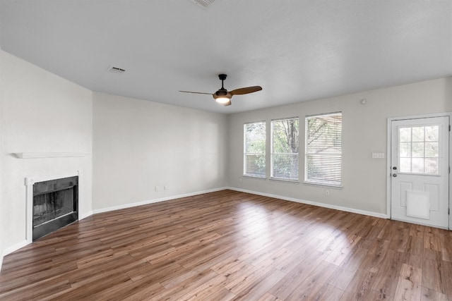 unfurnished living room featuring ceiling fan and hardwood / wood-style flooring