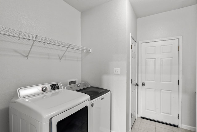 clothes washing area with separate washer and dryer and light tile patterned floors