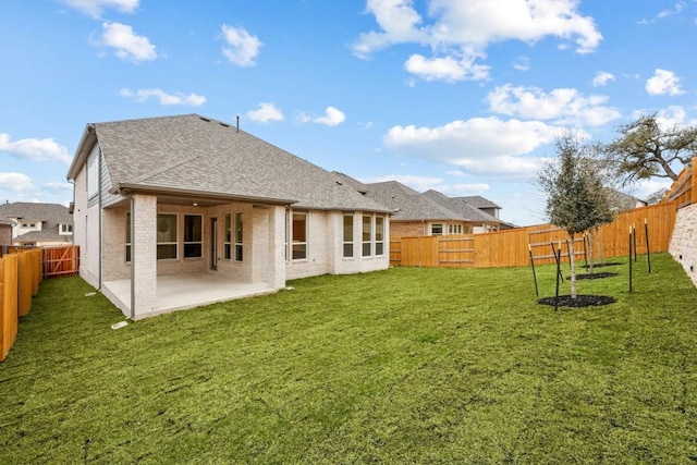 back of house with a patio and a lawn