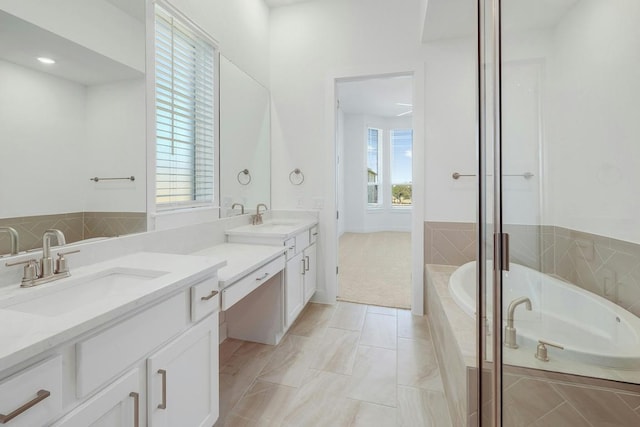bathroom with double vanity, a garden tub, and a shower stall