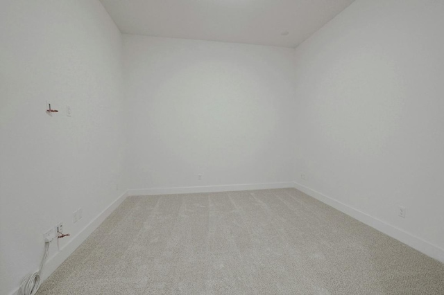 empty room with light colored carpet and baseboards