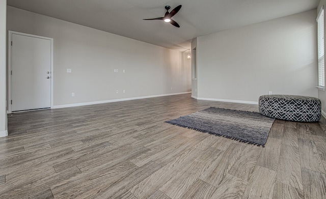 empty room with baseboards, a ceiling fan, and wood finished floors