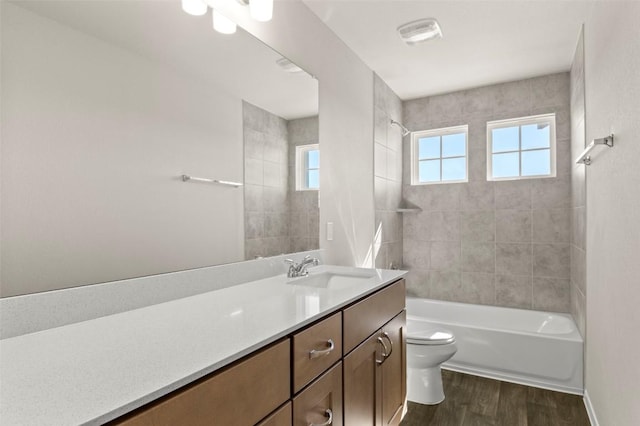 160 Lavender Ln, Elgin, TX 78621 - full bathroom featuring toilet, wood finished floors, vanity, and shower / tub combination