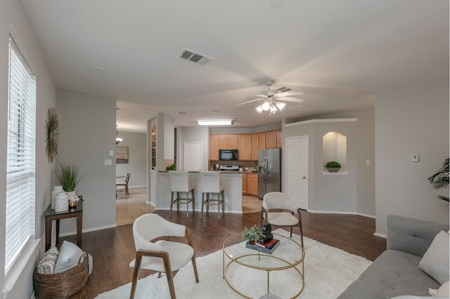 living room with ceiling fan, a wealth of natural light, and light wood-type flooring