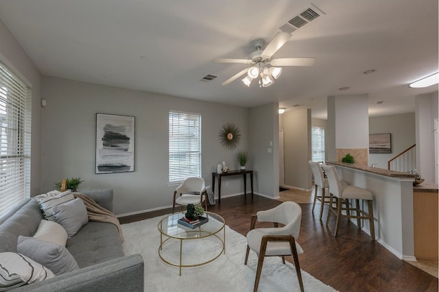 living room featuring dark wood-type flooring and ceiling fan