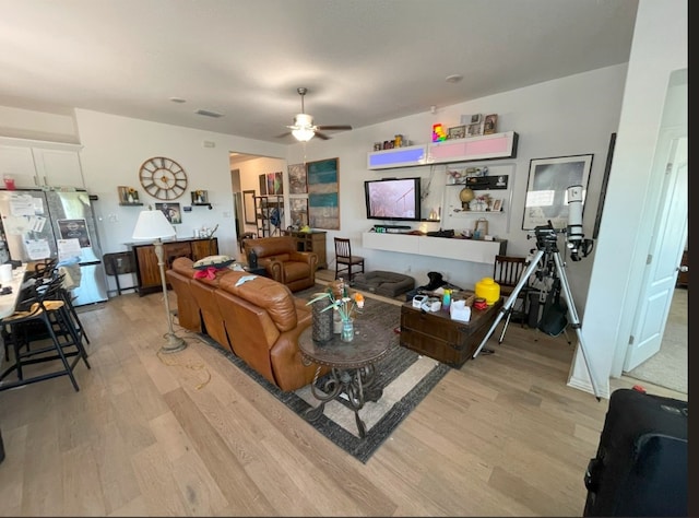 living room featuring light hardwood / wood-style floors and ceiling fan