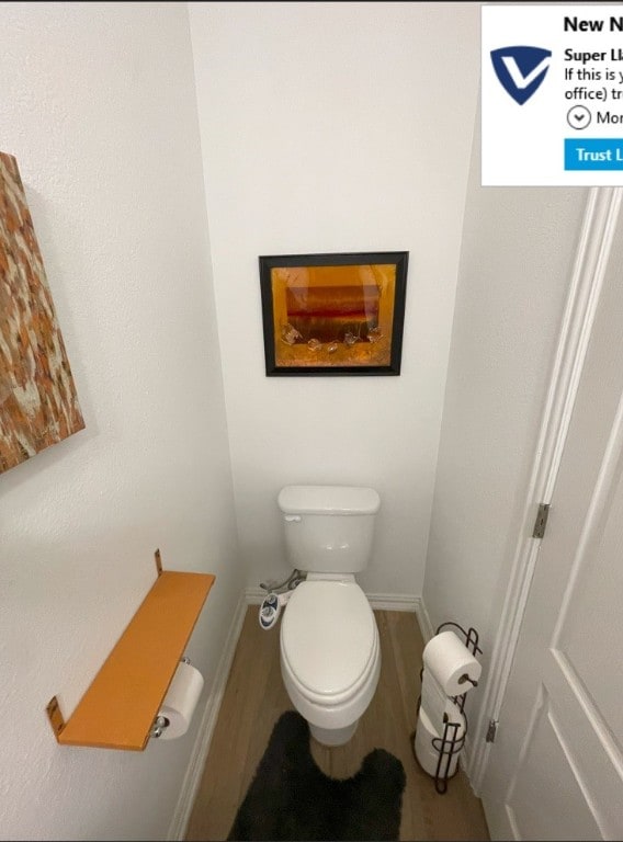 bathroom with toilet and wood-type flooring