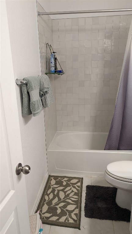 bathroom featuring toilet, shower / tub combo with curtain, and tile patterned flooring