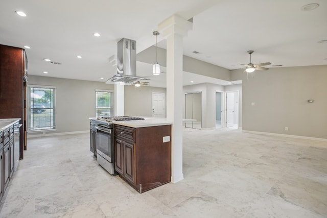 kitchen with stainless steel range with gas stovetop, decorative columns, ceiling fan, island exhaust hood, and pendant lighting