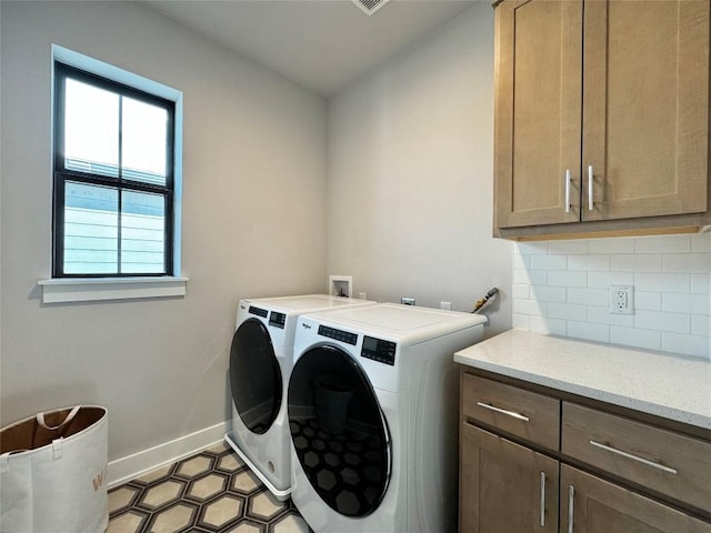 laundry room with washer and clothes dryer and cabinets