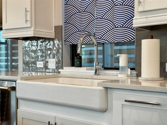 kitchen with dishwasher, light stone countertops, and backsplash