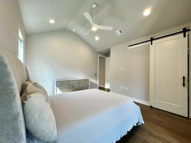 bedroom featuring dark hardwood / wood-style floors, ceiling fan, lofted ceiling, and a barn door