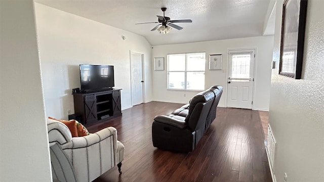 living room with dark hardwood / wood-style flooring, ceiling fan, and vaulted ceiling