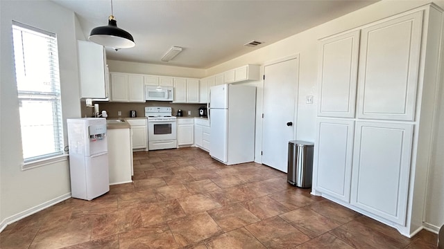 kitchen with a healthy amount of sunlight, white cabinetry, pendant lighting, and white appliances