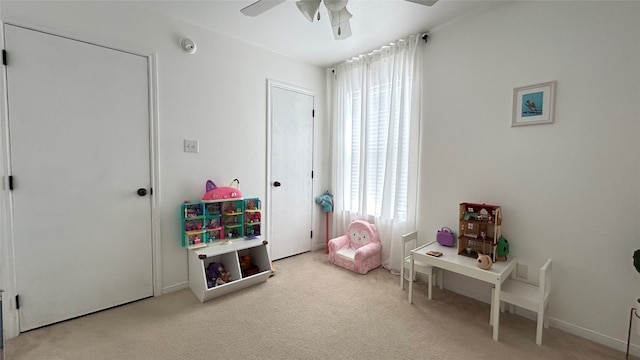 recreation room featuring light colored carpet and ceiling fan