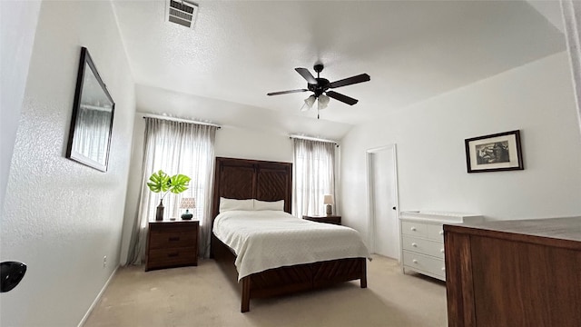 bedroom with ceiling fan, lofted ceiling, and light colored carpet