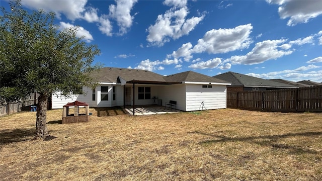 rear view of property featuring a patio and a lawn