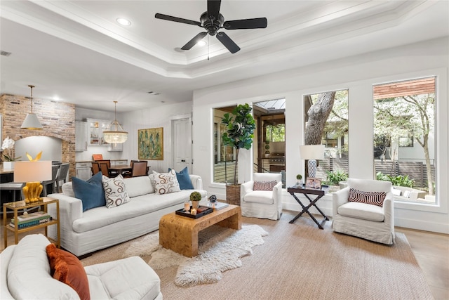 living room with a tray ceiling and ceiling fan