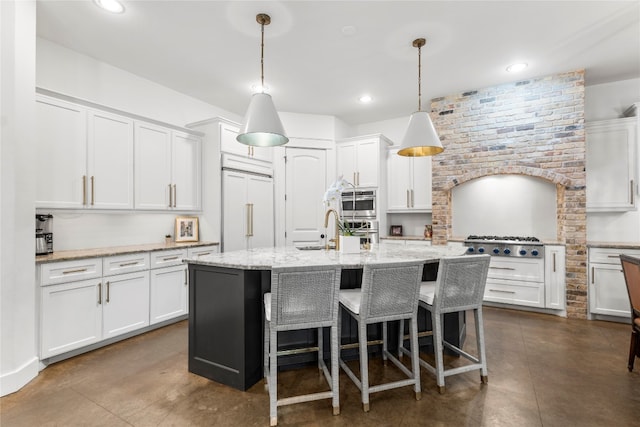 kitchen with a kitchen island with sink, stainless steel appliances, white cabinets, and pendant lighting