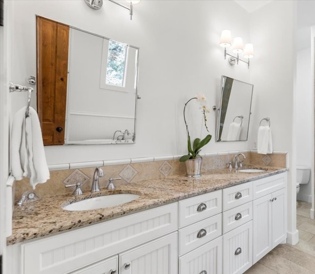 bathroom featuring toilet, vanity, and tile patterned flooring