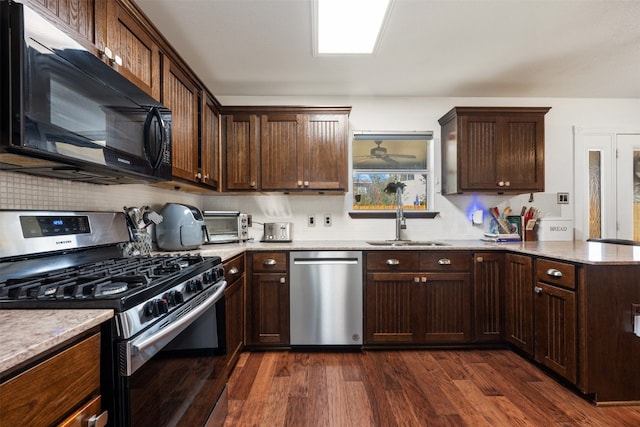 kitchen with decorative backsplash, appliances with stainless steel finishes, dark wood-type flooring, and sink