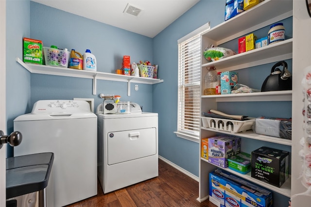 clothes washing area with washer and clothes dryer, dark wood-type flooring, and a wealth of natural light