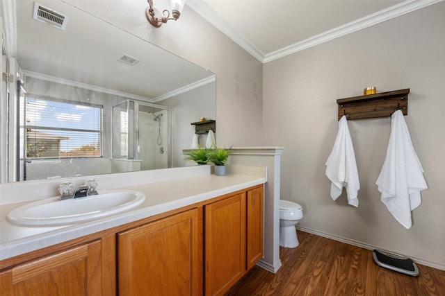 bathroom featuring vanity, a shower with door, crown molding, toilet, and wood-type flooring