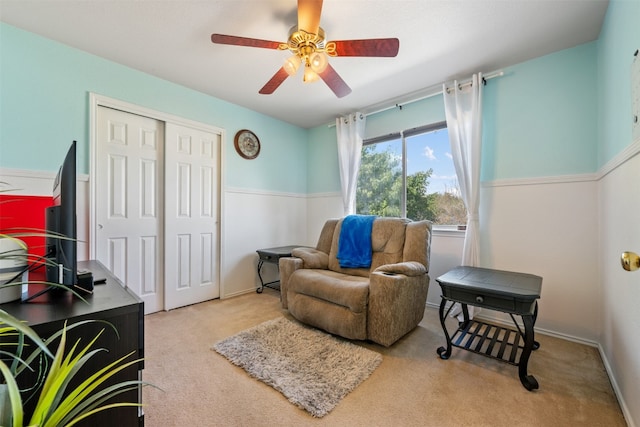 living area with ceiling fan and light carpet