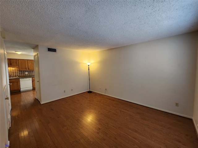 unfurnished room with a textured ceiling and dark hardwood / wood-style flooring