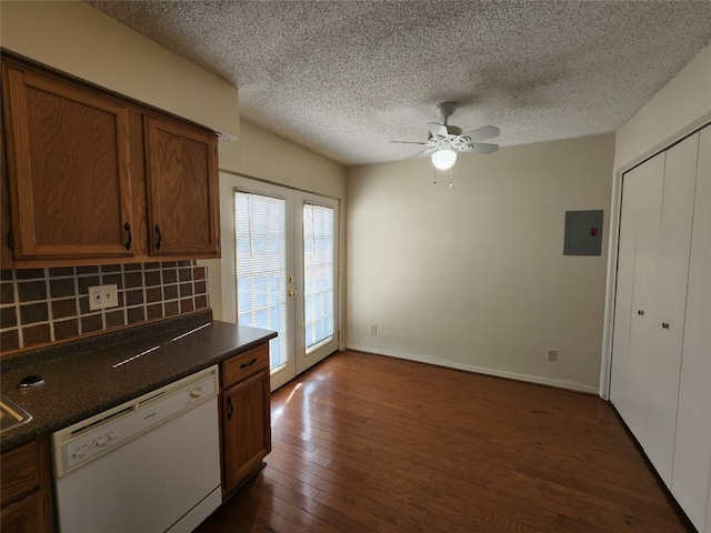 kitchen featuring dark wood-type flooring, backsplash, white dishwasher, electric panel, and ceiling fan