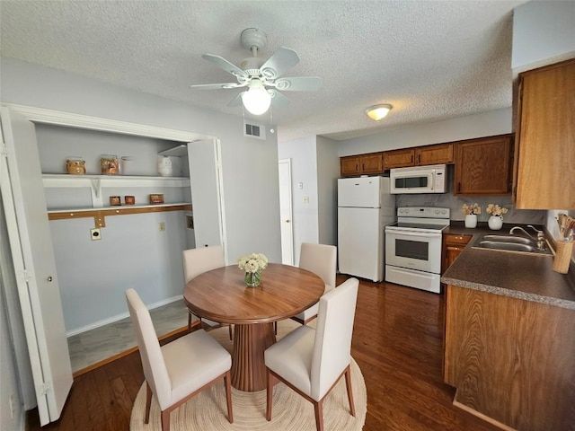 dining area featuring dark hardwood / wood-style flooring, sink, a textured ceiling, and ceiling fan