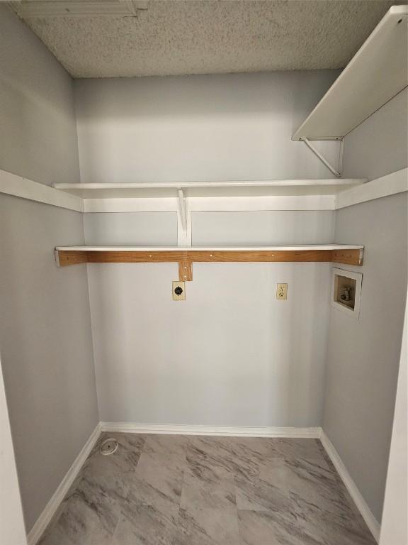 laundry room with hookup for an electric dryer, hookup for a washing machine, and a textured ceiling