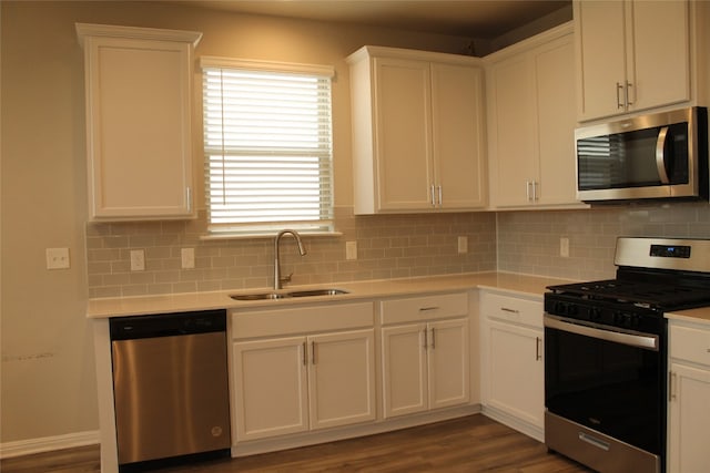 kitchen with dark hardwood / wood-style flooring, sink, white cabinets, and appliances with stainless steel finishes