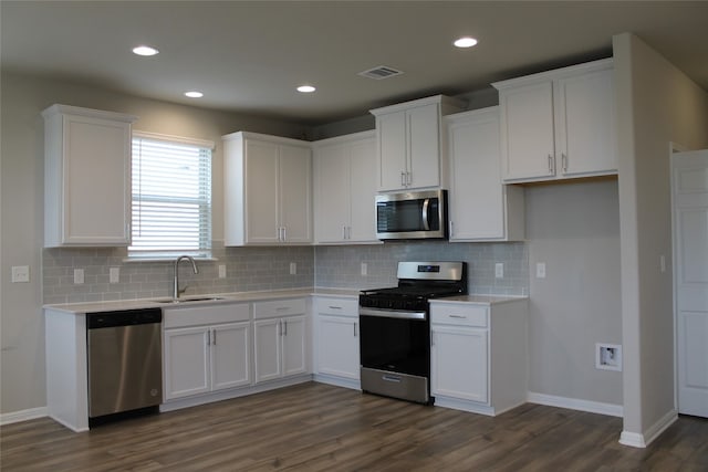 kitchen featuring white cabinetry, sink, stainless steel appliances, tasteful backsplash, and dark hardwood / wood-style flooring