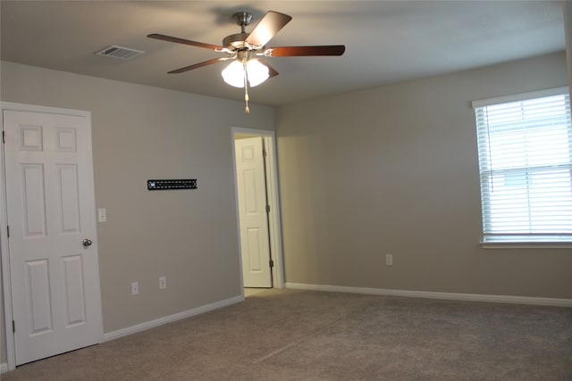 carpeted spare room featuring ceiling fan