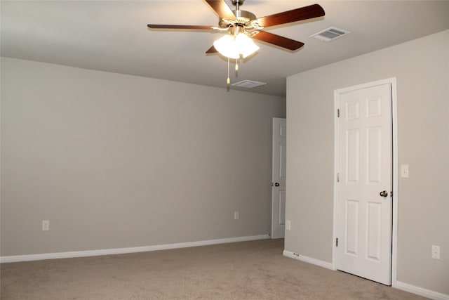 empty room featuring ceiling fan and light carpet