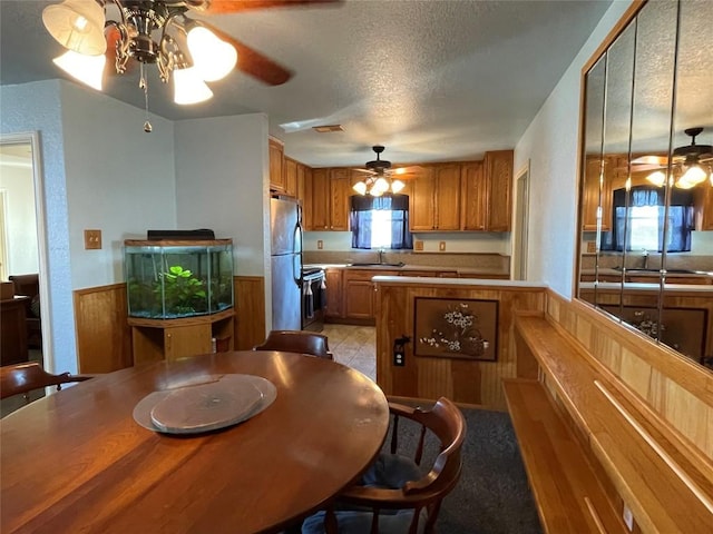 kitchen featuring sink, a textured ceiling, light tile patterned flooring, kitchen peninsula, and stainless steel appliances