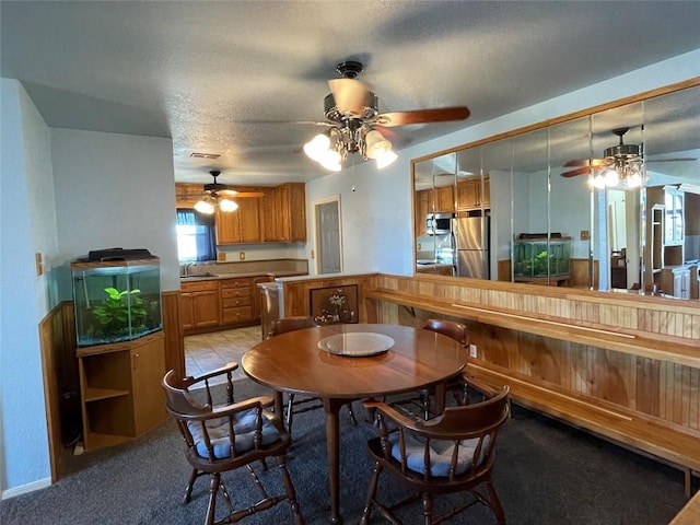 carpeted dining room featuring a textured ceiling, ceiling fan, and sink