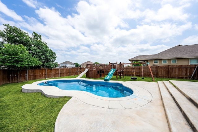 view of swimming pool featuring a yard, a patio, a water slide, and a playground