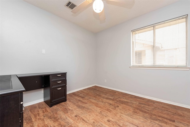 home office featuring ceiling fan, a textured ceiling, and light wood-type flooring