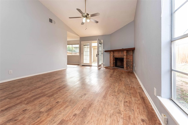 unfurnished living room with hardwood / wood-style flooring, high vaulted ceiling, a fireplace, and ceiling fan